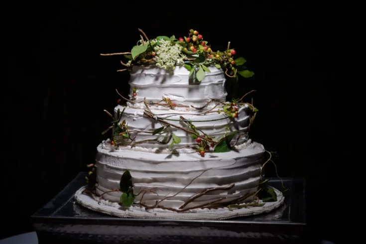 white custom wedding cake with leaves as decoration